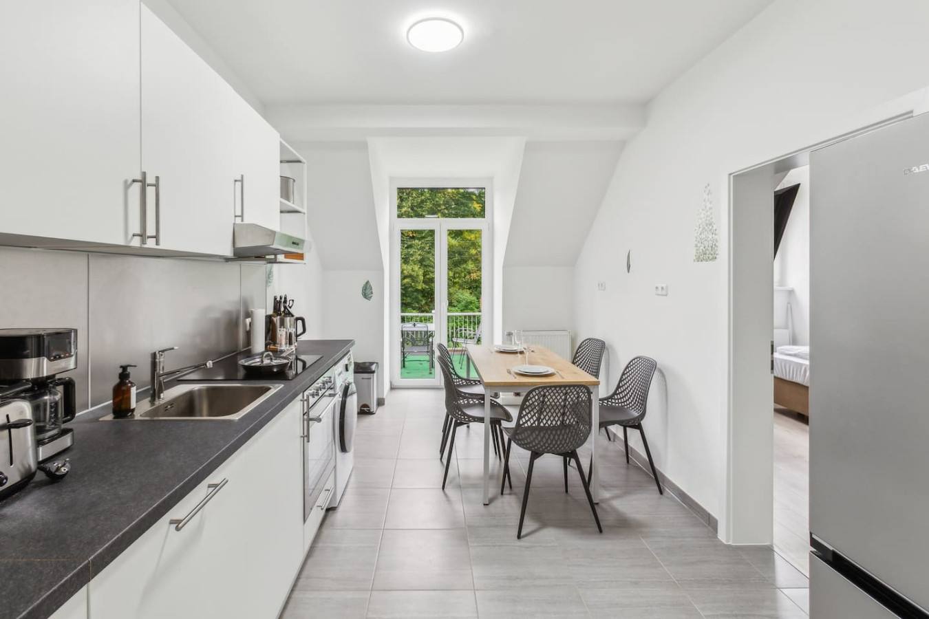 Küche mit Essplatz und Balkon in einem Apartment in Jena